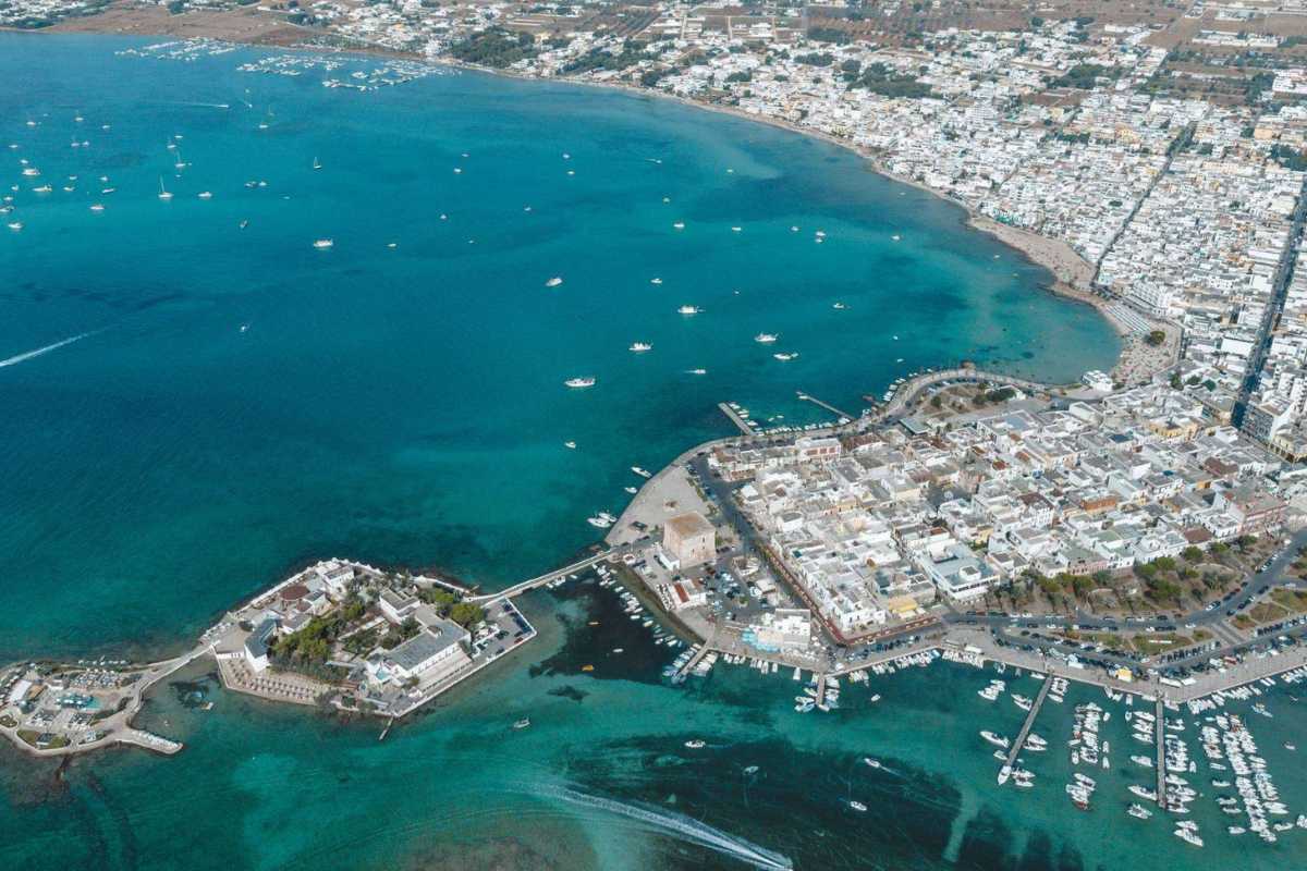 Vista panoramica aerea su Porto Cesareo, con il mare azzurro, il paese e la costa sabbiosa, atmosfera estiva e rilassata